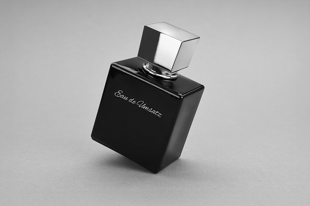 Schwarzer Parfumflakon in schräger Perspektive mit glänzender Oberfläche und reflektierendem Metallverschluss