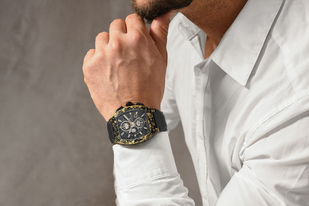 Produktfotografie einer markanten Armbanduhr am Handgelenk eines Mannes mit weißem Hemd.